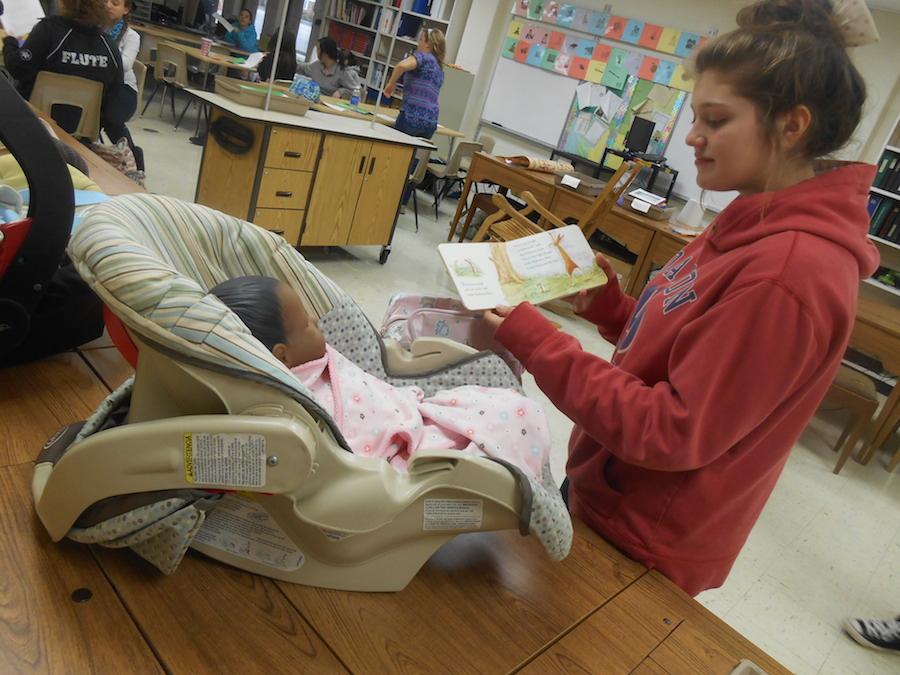 Sophomore Ally Ratzel reads a childrens book to the baby she has been assigned in Parenting class. Northmonts Parenting class focuses on parenting skills and child development, which bring awareness to the struggles of raising an infant.
