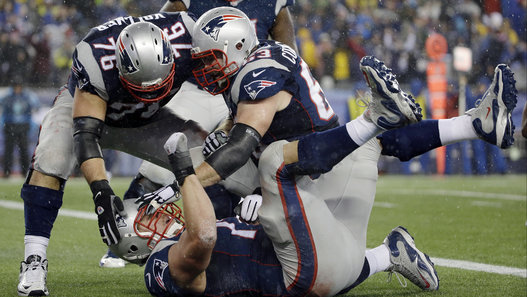 New England Patriots tackle Nate Solder is congratulated by his teammates after scoring on a 16-yard touchdown pass during the second half of the NFL football AFC Championship game against the Indianapolis Colts Sunday, Jan. 18, 2015, in Foxborough, Mass. (AP Photo/Matt Slocum - Photo courtesy of Huffington Post)