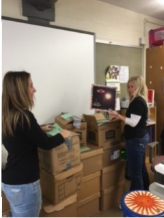 Junior Anya Young helps Spanish teacher Ms. Jenna Harris pack for the move to the new building.