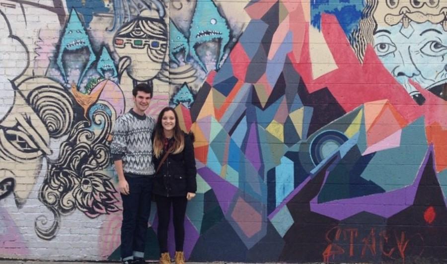 Juniors Nicholle Weidner and Cole Peyton stand in front of a piece of graffiti art in Columbus, Ohio.