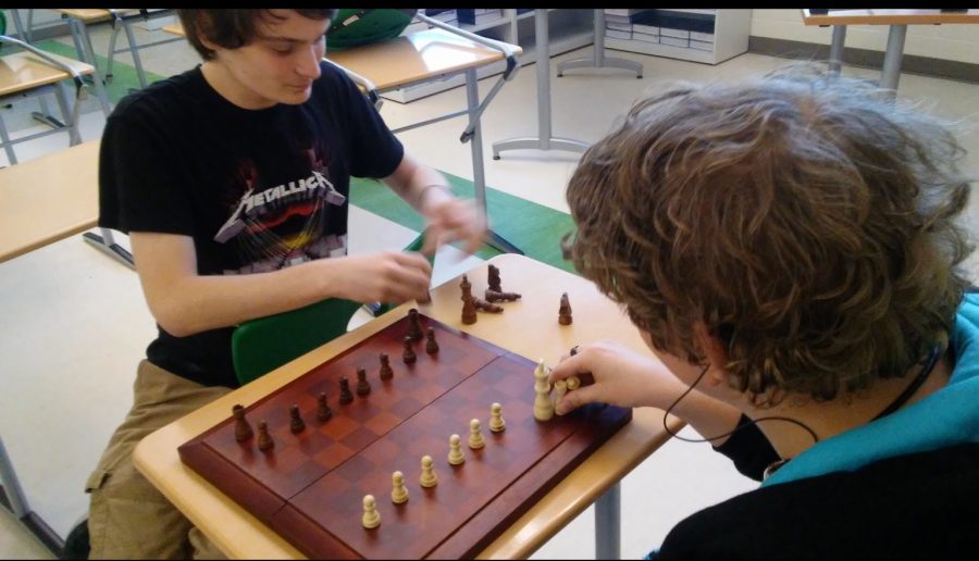 Juniors Dillon Lucente 
and Noah Schneider set up the chess board. 