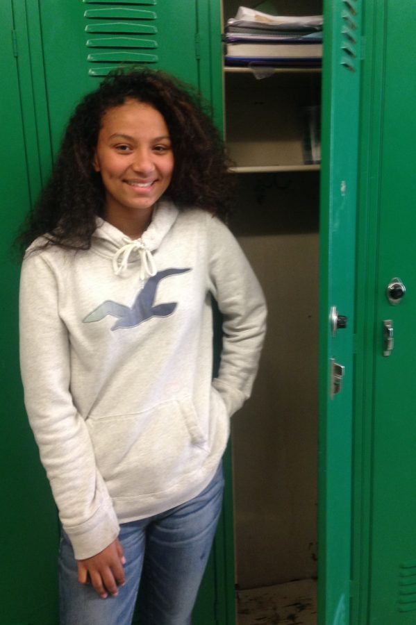 Eighth grader Shae Bell stands by the locker where she saw the smoke.