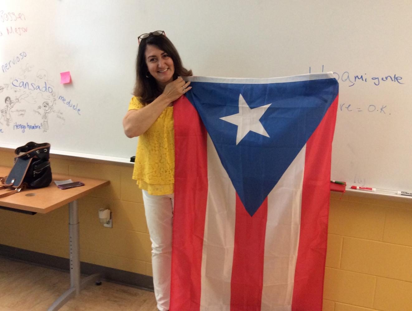 Ms. Sandra Ocasio holds the Puerto Rican flag.