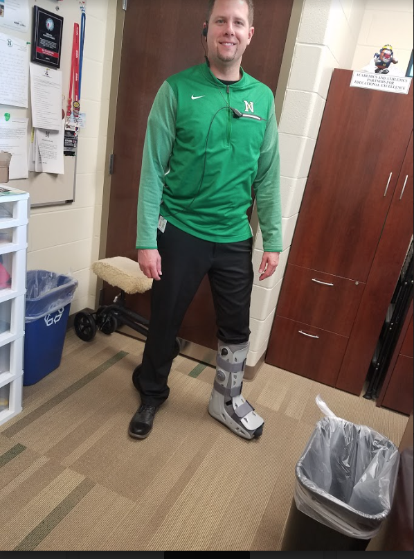 Mr. Micah Harding wears a boot to protect his torn Achilles tendon