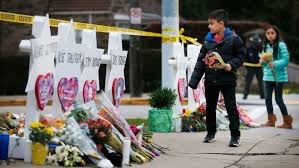 Men, women, and children pay their respects to the victims of the shooting. 