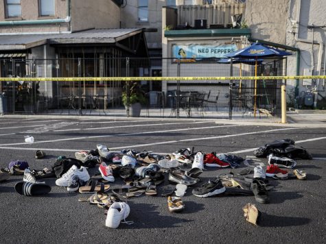 Shoes of the victims are piled at the scene of the shooting. John Minchillo/AP