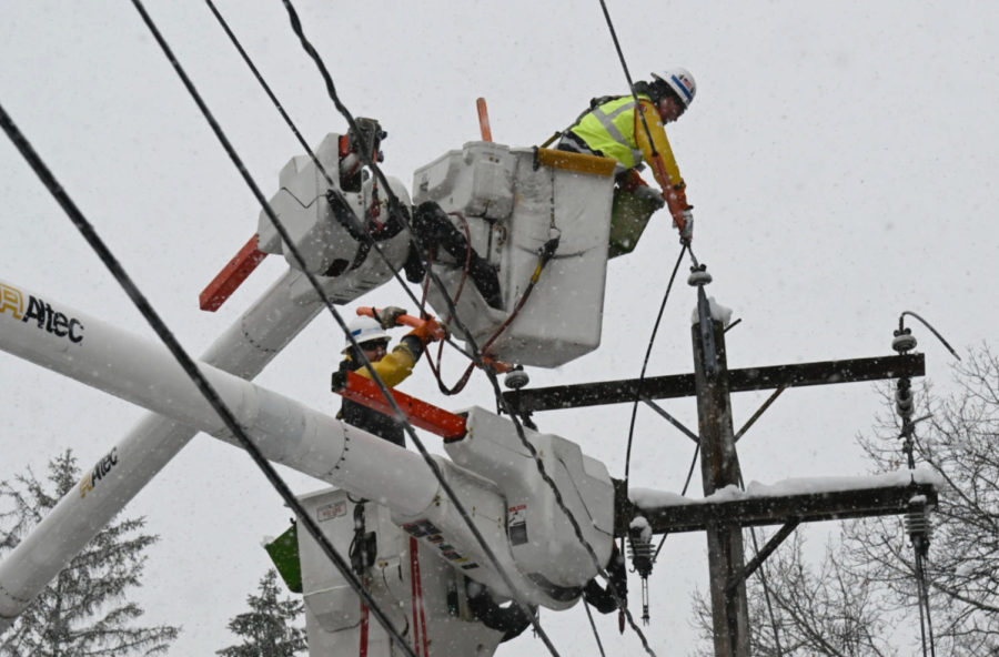 National Grid lineman Jim Sheeran, top, and Matthew Jukes fix a primary power line during a snowstorm in Ballston Lake, N.Y., on Tuesday. Hans Pennink / AP