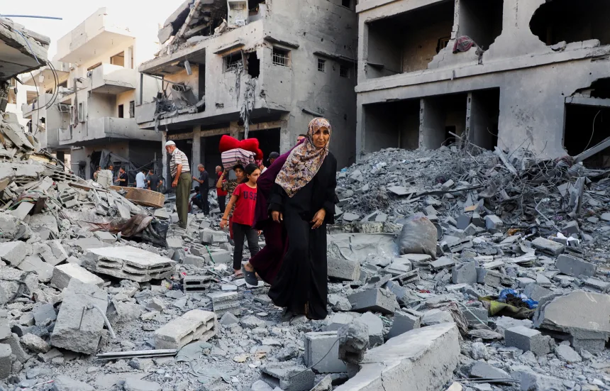 Palestinians look at the aftermath of Israeli strikes
