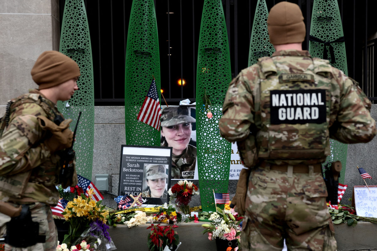 National Guard soldiers look at a makeshift memorial honoring National Guard soldier Sarah Beckstrom